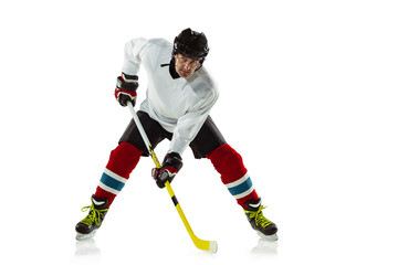 Speed. Young male hockey player with the stick on ice court and white background. Sportsman wearing...