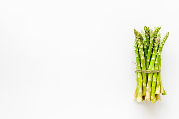 Bunch of asparagus steams on white background top-down copy space