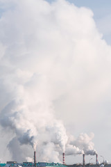 Fototapeta na wymiar Vertical banner of industrial chimneys with heavy smoke causing air pollution on gray sky background