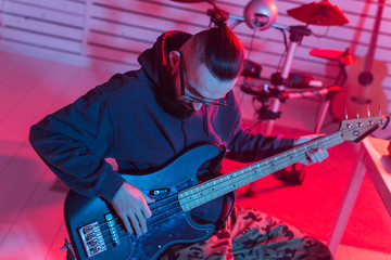 Obraz premium Create music and a recording studio concept - Bearded funny man guitarist recording electric guitar track in home studio