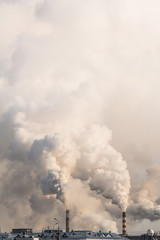 Vertical banner of industrial chimneys with heavy smoke causing air pollution on gray sky background
