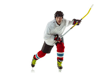 Target. Young male hockey player with the stick on ice court and white background. Sportsman...