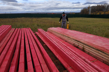 Worker covers wooden boards with protective paint.