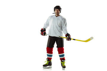 Champion. Young male hockey player with the stick on ice court and white background. Sportsman...