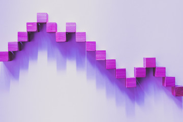 Fototapeta premium Declining pink graphic curve made with wooden boxes. Financial concept