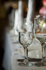 A wine glass stands on a table on a white tablecloth