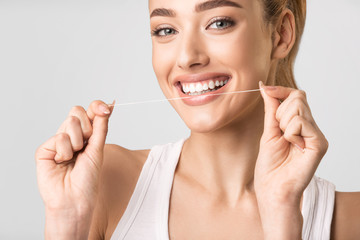 Cheerful Girl Flossing Perfect Teeth Smiling Posing Over Gray Background
