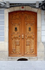 Brown wooden carved door with metal knockers. Jaca, Huesca, Aragon, Spain