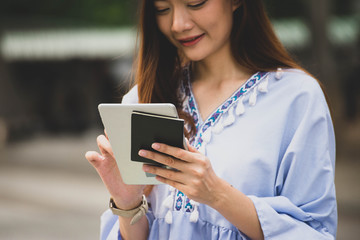 Asian Thai girl using mobile phone in business market.Person front view of Young Woman holding...