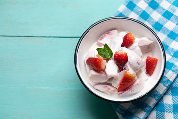 Strawberries and cream dessert on turquoise background