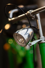 Vintage front headlamp on a green holland bicyle