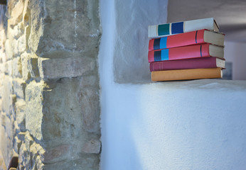 Five stacked books placed inside a space in wall in focus indoor open space white wall studio rustic stone wall in country house