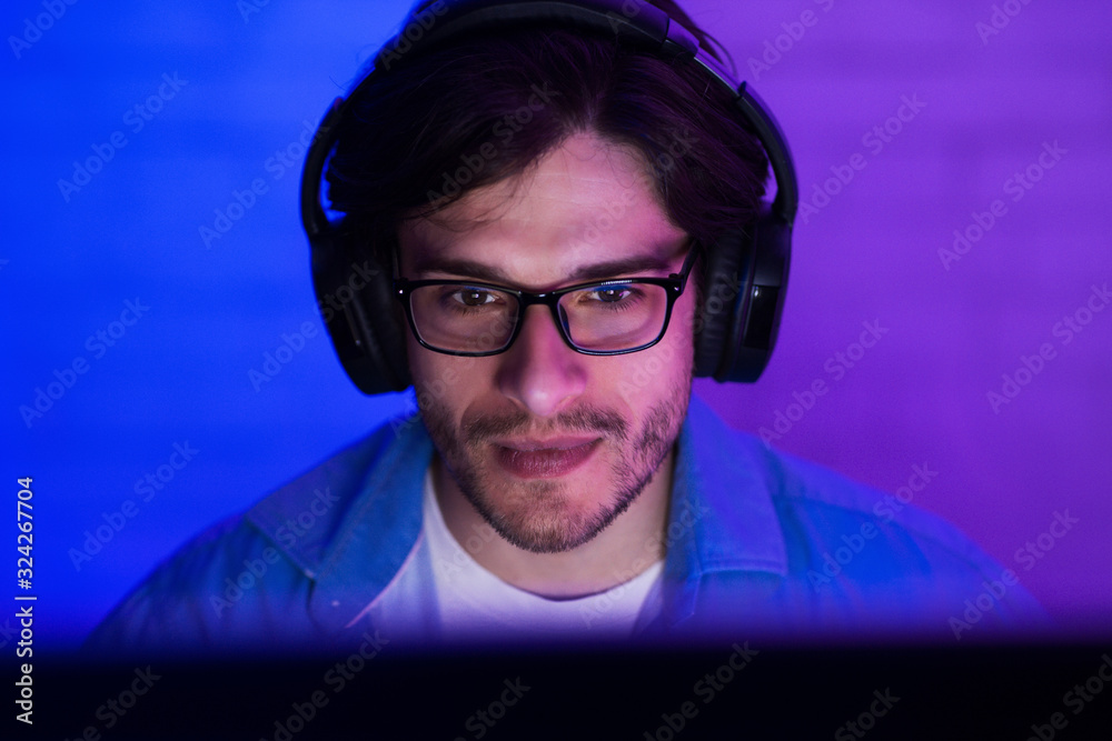 Poster guy at desktop pc playing computer game indoor at night