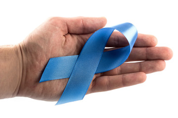 close up of male hand holding sky blue prostate cancer awareness ribbon over white background