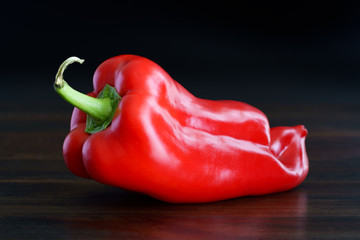 Organically grown ugly red pepper from local farmers market. High resolution, dark wood background