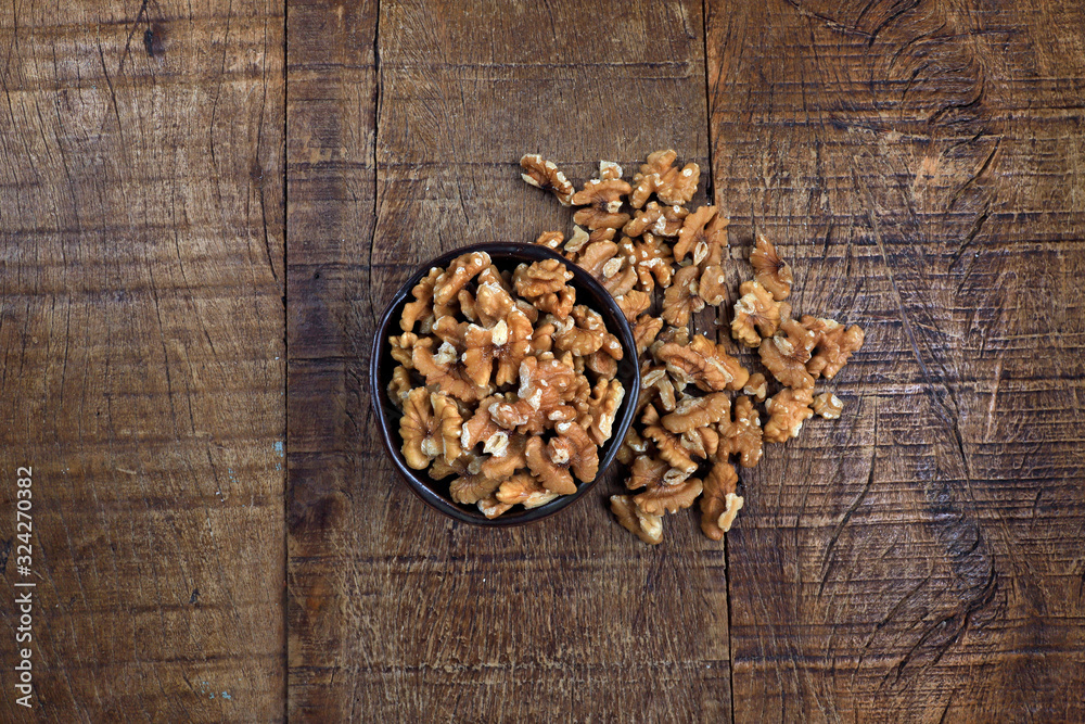 Wall mural bowl with persian walnut on wooden table. space for text