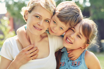 portrait of a happy family outdoors. mom with children in the summer. Mother and kids.