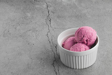raspberry ice cream sorbet in a ceramic bowl on a gray background