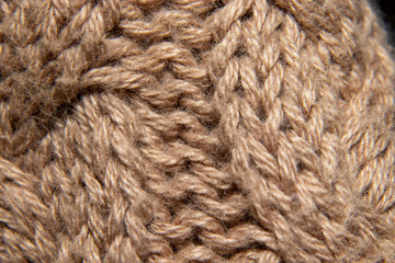 detail of embroidered wool sweater, braided in cream or camel, fabric detail