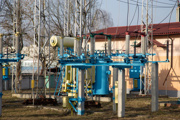 Fototapeta na wymiar Large electricity transformer at the sub station. Industrial power transmission through the power line device.