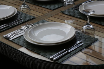 empty plate with fork and knife on wooden table