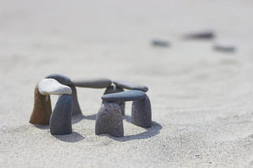 Balanced stones on a sand background. Little stonehenge
