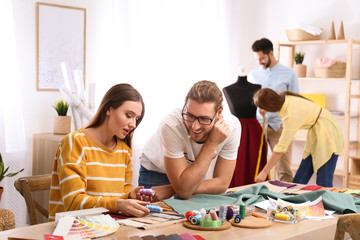 Fashion designers creating new clothes in studio