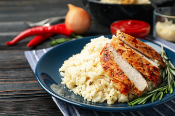 Delicious risotto with chicken on plate, closeup