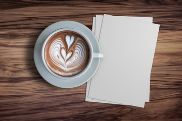 Blank paper and a cup of hot Espresso coffee with beautiful latte art on the wodden table