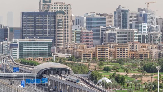 Dubai Golf Course with a cityscape of Gereens and tecom districts at the background aerial timelapse. Traffic on sheikh zayed road with junction and metro station