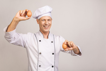 Portrait of smiling senior baker. Isolated over white background.