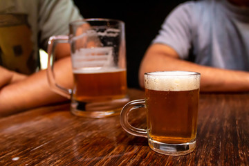 Small beer chopp. Big chopp and people on the background. Schop, Schopp, Schoppen.