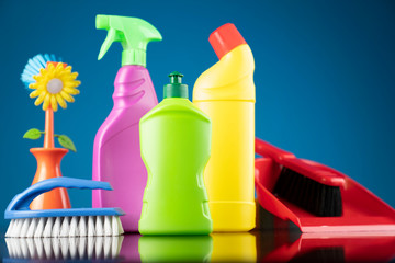 Spring house cleaning. Colorful cleaning kit on blue background.