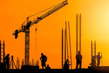 silhouette of cranes on construction site at sunset