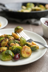 Delicious roasted brussels sprouts with red beans and peanuts served on grey marble table