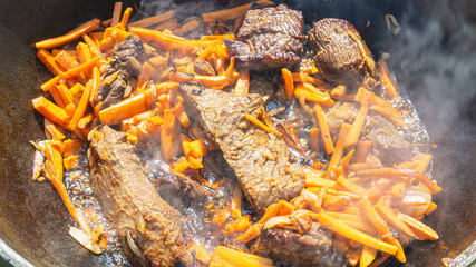 Step-by-step process of cooking pilaf in a cast iron cauldron.