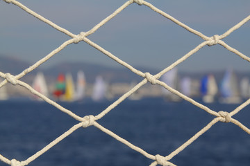 Detail image of wooden pulley with ropes of an classical sailing yacht. ocean and sailing boats in...
