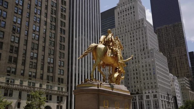 Cinematic shot rotating around golden statue with NYC buildings parallax in midtown manhattan
