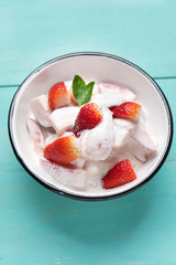 Strawberries and cream dessert on turquoise background