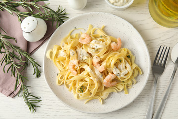Delicious pasta with shrimps served on white wooden table, flat lay