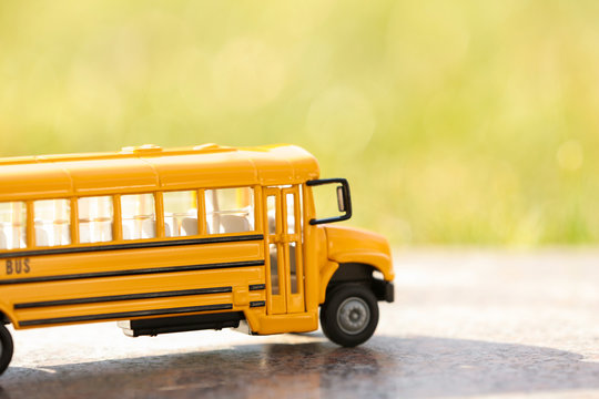 Yellow toy school bus outdoors on sunny day. Student's transport