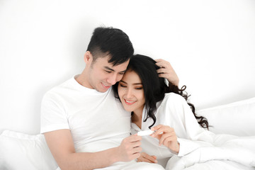 young couple having test pregnant in bed