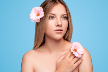 Beautiful lady with flowers touching skin