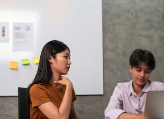 Fototapeta premium In selective focus of beautiful woman and blurred Young business people working ,with colleagues team meeting,blurry light around