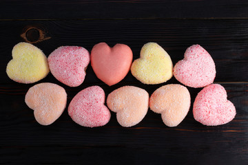 Pattern of cakes in the shape of heart on wooden background. Top view