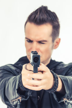 Close-up of man aiming with a gun.