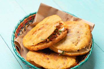 Mexican gorditas with pressed chicharron on turquoise background