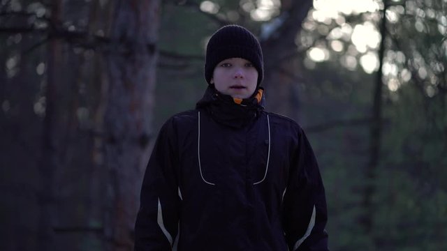 Portrait of teenager in a winter pine forest.