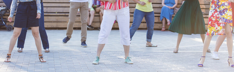 Social dance and flashmob concept - Fun and dance with in the summer on a city street. Close-up of dancers feet.