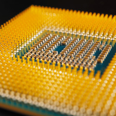 Processor of a computer lies on a dark matte surface. Close-up. CPU, semiconductors, pins and connectors. Illustration: electronic and computing equipment, computer hardware. Macro